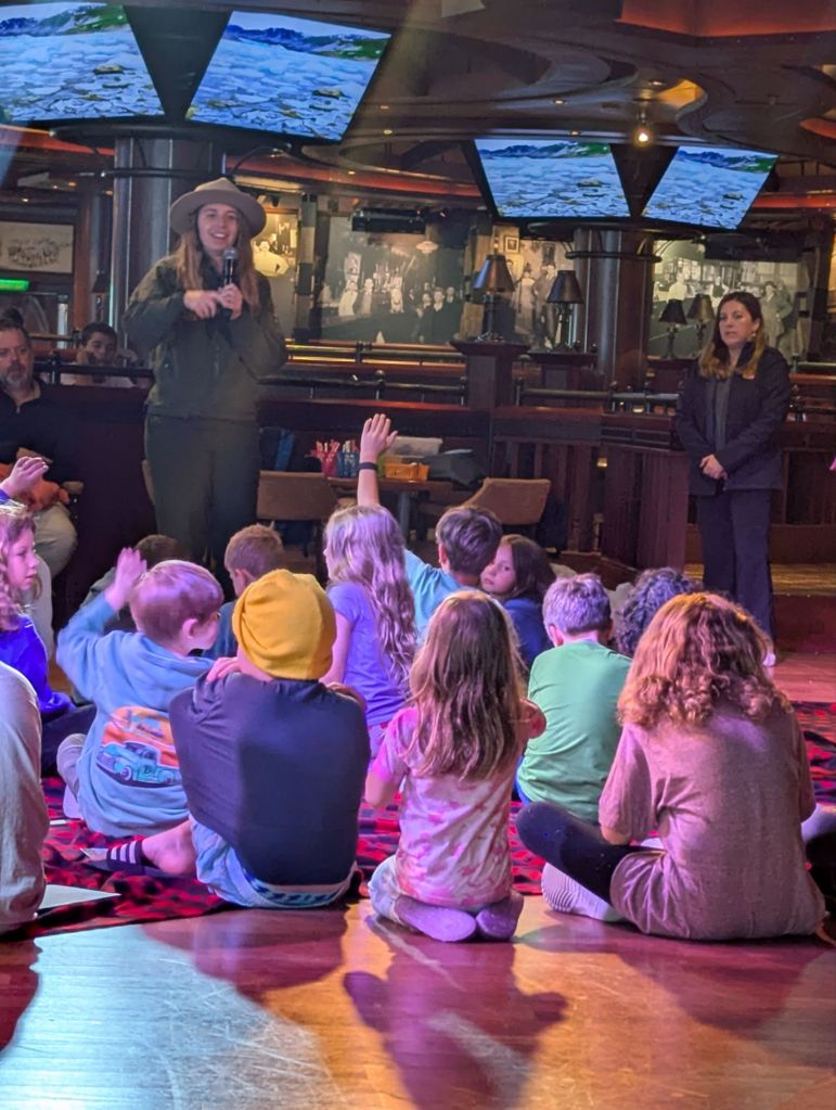 children sitting on the floor listening to a national park service ranger